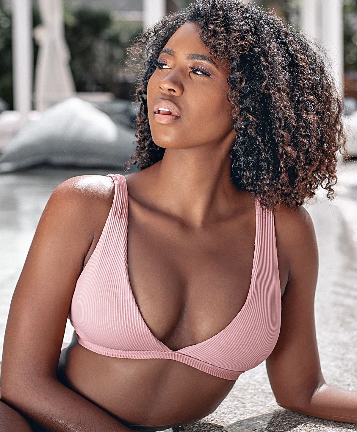 Model in a stylish white swimsuit, outdoors.